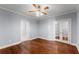 Bright bedroom with hardwood floors, ceiling fan, and glass-paned French doors at 1348 Ewing Creek Dr, Dacula, GA 30019