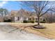 Brick home featuring a curved driveway, lush landscaping, and a beautifully designed exterior at 1348 Ewing Creek Dr, Dacula, GA 30019