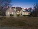 Lovely home with festive holiday lights, a manicured lawn, and a welcoming facade at twilight at 1348 Ewing Creek Dr, Dacula, GA 30019