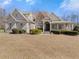 Charming home featuring a brick facade, lush landscaping, and a welcoming covered porch at 1348 Ewing Creek Dr, Dacula, GA 30019