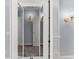 Elegant hallway showcasing white trim and baseboards, complemented by stylish wall sconces and modern doors at 1348 Ewing Creek Dr, Dacula, GA 30019