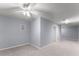 Carpeted hallway with access to rooms, ceiling fan, and light blue walls at 1348 Ewing Creek Dr, Dacula, GA 30019