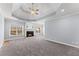 Spacious living room with gray carpet, fireplace, ceiling fan, and large windows at 1348 Ewing Creek Dr, Dacula, GA 30019