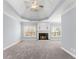 Bright living room with fireplace, large windows and gray carpeting at 1348 Ewing Creek Dr, Dacula, GA 30019