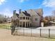 Elegant brick home with two-story porch, fenced yard, attached garage and well manicured backyard on a sunny day at 1348 Ewing Creek Dr, Dacula, GA 30019