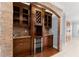 Custom wet bar with stacked stone and a wine fridge adjacent to hardwood flooring and cabinets at 1348 Ewing Creek Dr, Dacula, GA 30019