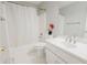 Clean, white bathroom with a shower-tub combo, vanity sink, and tiled floors at 3500 Parkwood Hills Ct, Snellville, GA 30078
