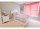 Charming bedroom features a white bed frame, bright window, and pastel-colored decorations at 3500 Parkwood Hills Ct, Snellville, GA 30078