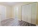 Bedroom featuring gray vinyl flooring, neutral walls, and closet with folding doors at 3500 Parkwood Hills Ct, Snellville, GA 30078