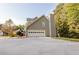 Side view of a gray two-story home with a two car garage and a concrete driveway at 3500 Parkwood Hills Ct, Snellville, GA 30078