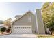 The garage side of the house showcases a well-kept lawn and mature trees, adding to curb appeal at 3500 Parkwood Hills Ct, Snellville, GA 30078