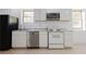 Bright kitchen with white cabinets, stainless dishwasher, and gray granite counters at 3500 Parkwood Hills Ct, Snellville, GA 30078