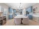 Open-concept kitchen boasts a large island, blue cabinetry, stainless appliances, and modern lighting fixtures at 650 Village Crest Dr, Suwanee, GA 30024