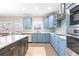 Modern kitchen with light blue cabinetry, stainless steel appliances, and a view to the outdoors at 650 Village Crest Dr, Suwanee, GA 30024