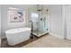 Bright main bathroom featuring a soaking tub and a glass shower with a rainfall shower head at 650 Village Crest Dr, Suwanee, GA 30024