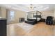 Spacious main bedroom featuring tray ceilings, hardwood floors, and a four-poster bed at 650 Village Crest Dr, Suwanee, GA 30024
