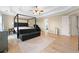 Bright main bedroom featuring tray ceilings and hardwood floors with an ensuite bath at 650 Village Crest Dr, Suwanee, GA 30024