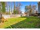 Lush green backyard with seating area, mature trees, and fenced perimeter at 981 Cobb Place Manor Dr, Marietta, GA 30066