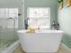 Updated bathroom featuring a soaking tub, window with blinds and a glass enclosed shower at 981 Cobb Place Manor Dr, Marietta, GA 30066