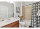Bright bathroom with a tub/shower combo and dark wood cabinets and a large mirror at 1205 New Haven Ct, Roswell, GA 30075