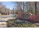 Welcoming entrance to Heritage at Roswell with a brick sign, guardhouse, and manicured landscaping at 1205 New Haven Ct, Roswell, GA 30075