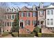 Charming brick townhome featuring multiple dormers, black shutters, and landscaped entrance at 1205 New Haven Ct, Roswell, GA 30075