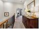 Upstairs hallway with wood banister and dark wood dresser with decorative lamps at 1205 New Haven Ct, Roswell, GA 30075