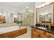 Main bathroom with a glass shower, tub, and dual vanities with granite countertops at 1205 New Haven Ct, Roswell, GA 30075