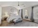 Bright main bedroom with a ceiling fan, neutral tones, and a zebra print bench at 1205 New Haven Ct, Roswell, GA 30075