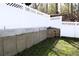 Backyard with a white fence and an unfinished concrete retaining wall for gardening or landscaping projects at 235 Woodland Way, Canton, GA 30114