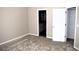 Bedroom showcasing plush carpeting, neutral walls, and an open doorway to a walk-in closet at 235 Woodland Way, Canton, GA 30114