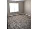 Bright bedroom featuring neutral walls, plush gray carpeting, and a window for natural light at 235 Woodland Way, Canton, GA 30114