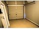 View of the interior of an empty one car garage with door parts and a door laying on the floor at 235 Woodland Way, Canton, GA 30114