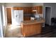 Eat-in kitchen features an island with sink, wood cabinets, and white appliances at 235 Woodland Way, Canton, GA 30114