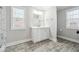 Bright bathroom featuring a white vanity, updated mirror and lights, and plank flooring at 40 Oak Forest Dr, Oxford, GA 30054