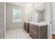 Bathroom featuring wood vanities, marble floors, and a large window with natural light at 40 Oak Forest Dr, Oxford, GA 30054