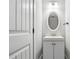 Bathroom featuring a white vanity, a round mirror and a white door at 40 Oak Forest Dr, Oxford, GA 30054