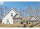 Charming new construction home featuring stone and white siding, complemented by mature trees and a bright blue sky at 40 Oak Forest Dr, Oxford, GA 30054