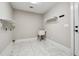 Laundry room features white tile floors, sink and built-in shelving at 40 Oak Forest Dr, Oxford, GA 30054