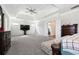 Large main bedroom with tray ceiling, ceiling fan, sitting area, and a view of the ensuite bathroom at 5095 Five Forks Trickum Sw Rd, Lilburn, GA 30047