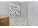 Corner soaking tub featuring floral designed curtains, tile surround, and a linen closet at 5729 Newnan Cir, Austell, GA 30106