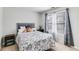 Bright carpeted bedroom featuring a large window, a bed and neutral paint at 5729 Newnan Cir, Austell, GA 30106