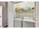 Functional laundry area features a washer and dryer, along with shelving for storing supplies at 5729 Newnan Cir, Austell, GA 30106