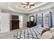 Spacious main bedroom featuring a trey ceiling, ceiling fan, wooded view, and dark wood furniture at 5729 Newnan Cir, Austell, GA 30106