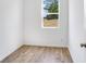 Empty bedroom featuring wood laminate floors and a bright window showcasing the surrounding landscape at 201 Groveton Ct, Euharlee, GA 30145