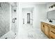 Modern bathroom with glass-enclosed shower, marble tile, and wooden vanity with black fixtures at 264 Haas Ave, Atlanta, GA 30316
