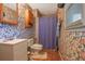 Small bathroom featuring colorful floral wallpaper, single vanity, toilet and shower with curtain at 210 Meadow View Dr, Grayson, GA 30017
