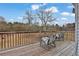 Wooden deck featuring three chairs and an open view of the backyard and surrounding trees at 210 Meadow View Dr, Grayson, GA 30017