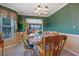 Well-lit dining room with green floral wallpaper, a large window, and wooden table set for six at 210 Meadow View Dr, Grayson, GA 30017
