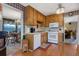 Functional kitchen adjacent to the dining and living areas with wood cabinetry and white appliances at 210 Meadow View Dr, Grayson, GA 30017